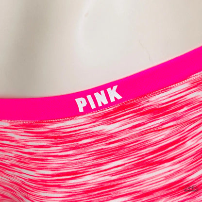 Jasně růžový elastický pas spodního prádla nebo sportovního oblečení s nápisem „PINK“ a pruhovanou látkou pod ním.