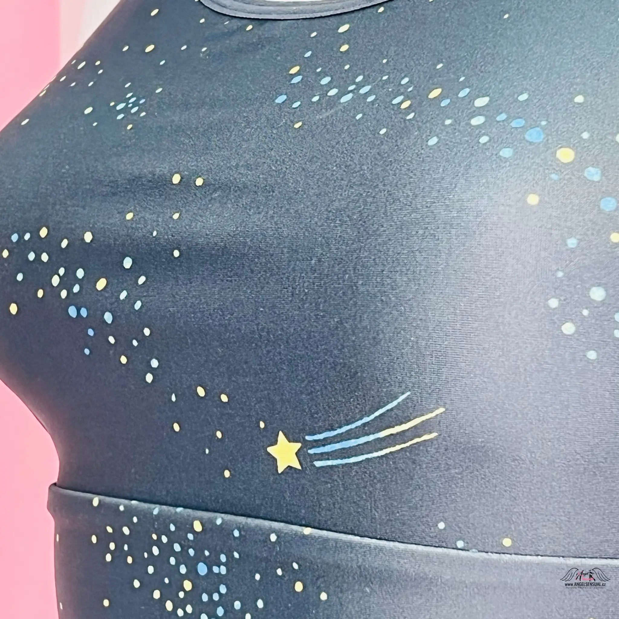 Tmavě modrá sportovní podprsenka nebo crop top zdobený barevnými fleky a designem malé hvězdy.